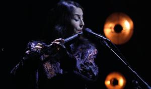 flutiste dans la pénombre devant un micro