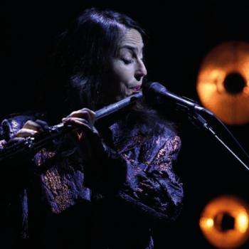 flutiste dans la pénombre devant un micro